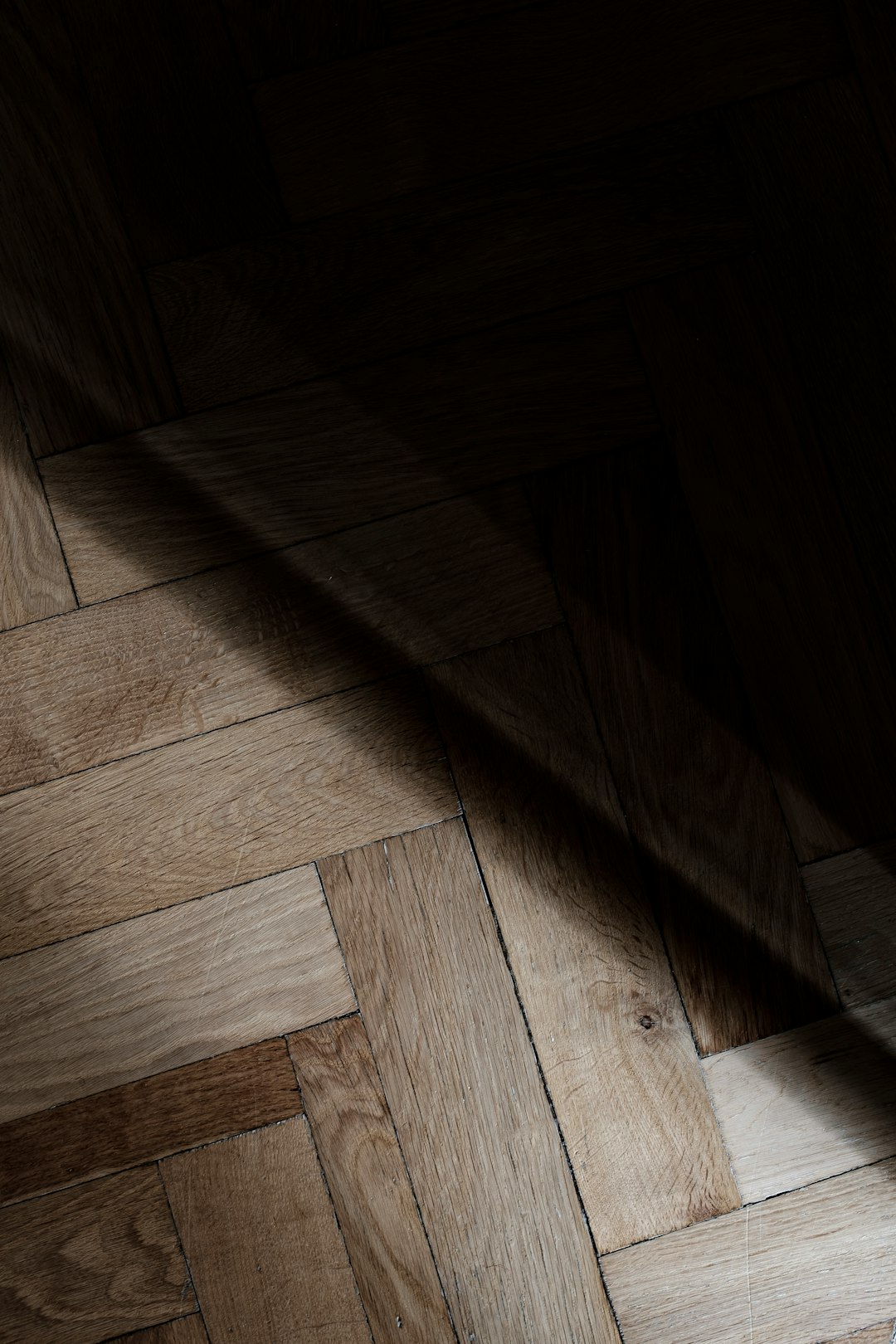 a-wooden-floor-with-a-light-shining-on-it-tckgl65kwgq