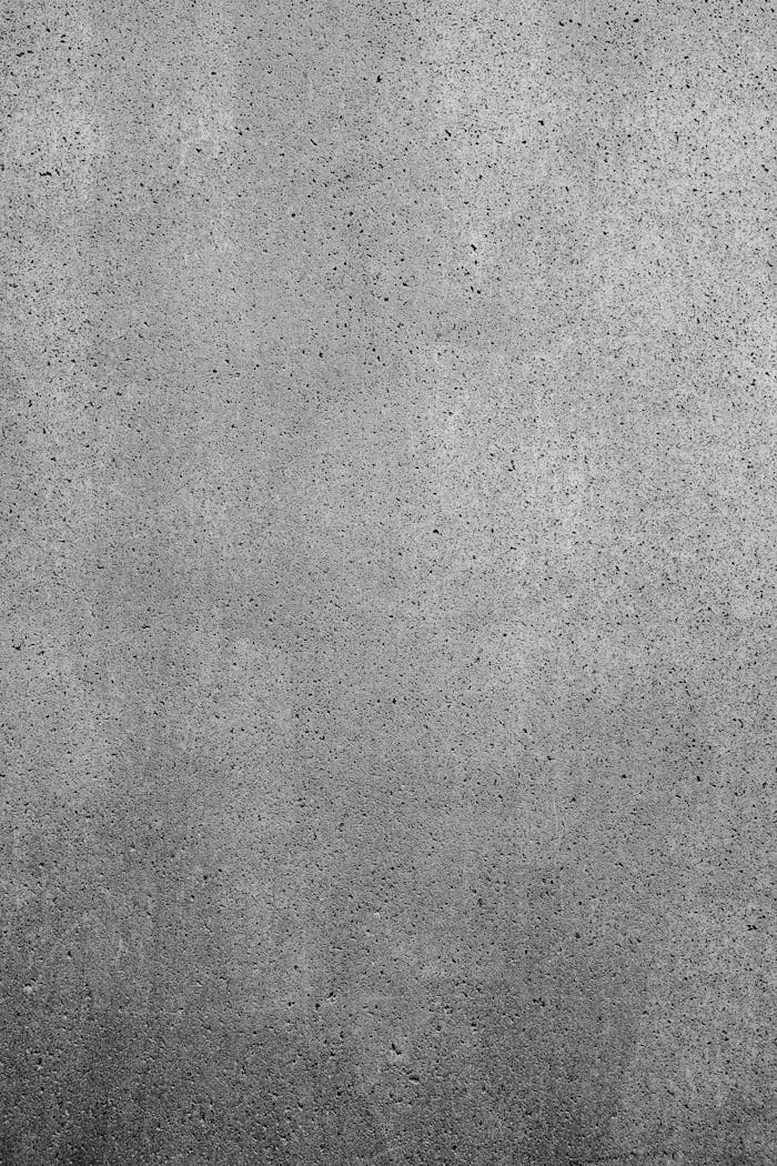 Detailed texture of a gray concrete wall with rough surface, perfect for industrial backgrounds.